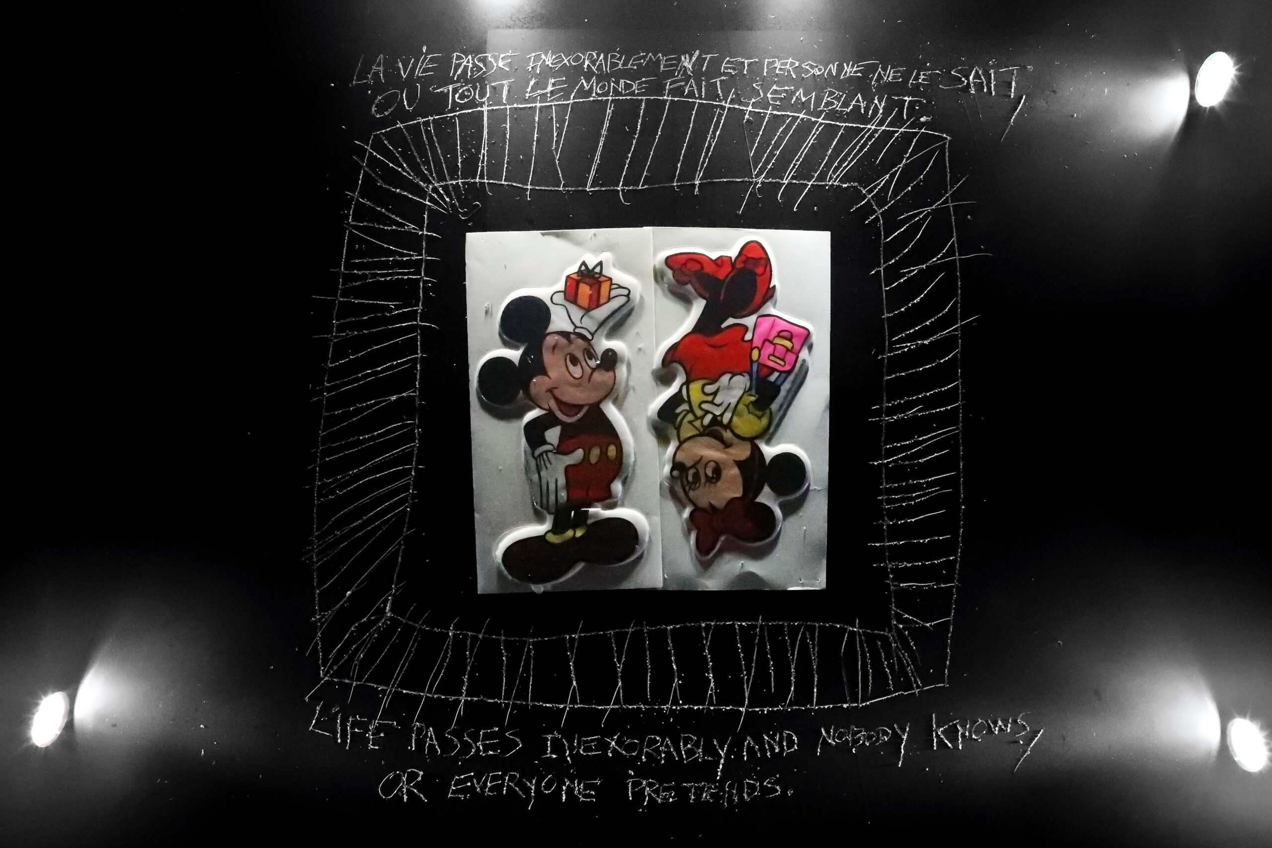 Personnages de Mickey et Minnie Mouse photographiés sur un fond noir, entourés de dessins et de phrases manuscrites — photographie de Richard Schlang